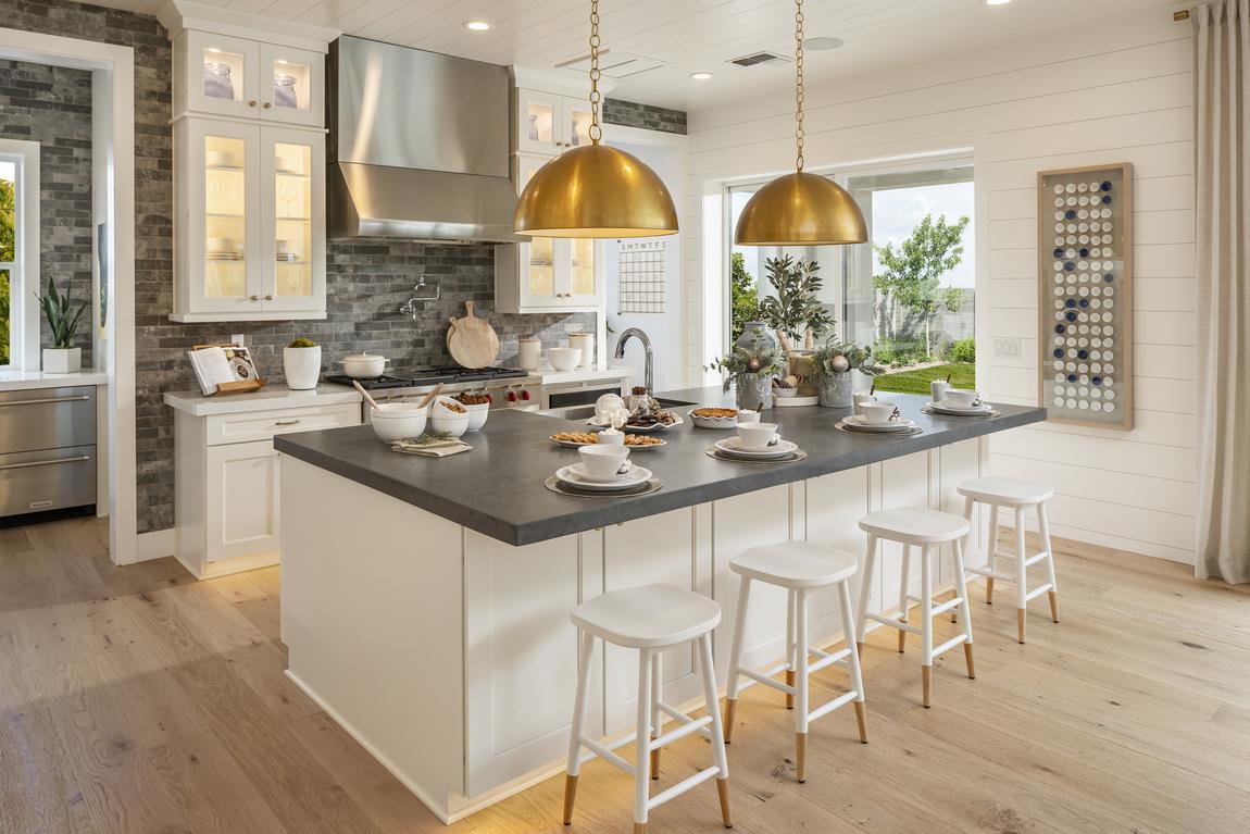 Modern farmhouse kitchen with brick accent wall and large island.