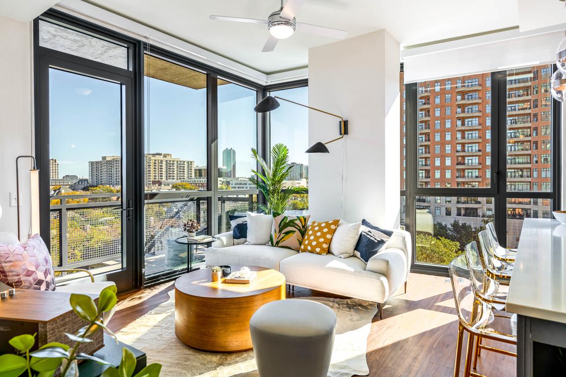 Aster Apartment building featuring white sofa, wall-to-floor glass windows and matte black accents