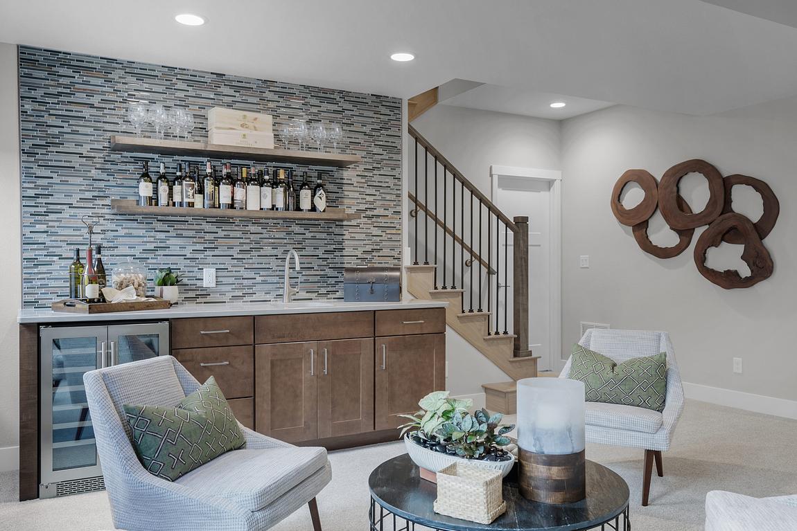 Bar in basement with stone tile backsplash and white chairs
